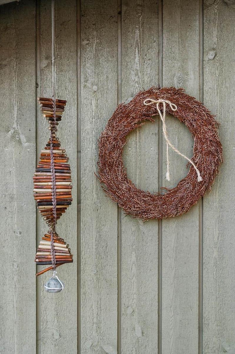An der Wand hängen ein Kranz und ein Fisch aus Holzstäbchen.