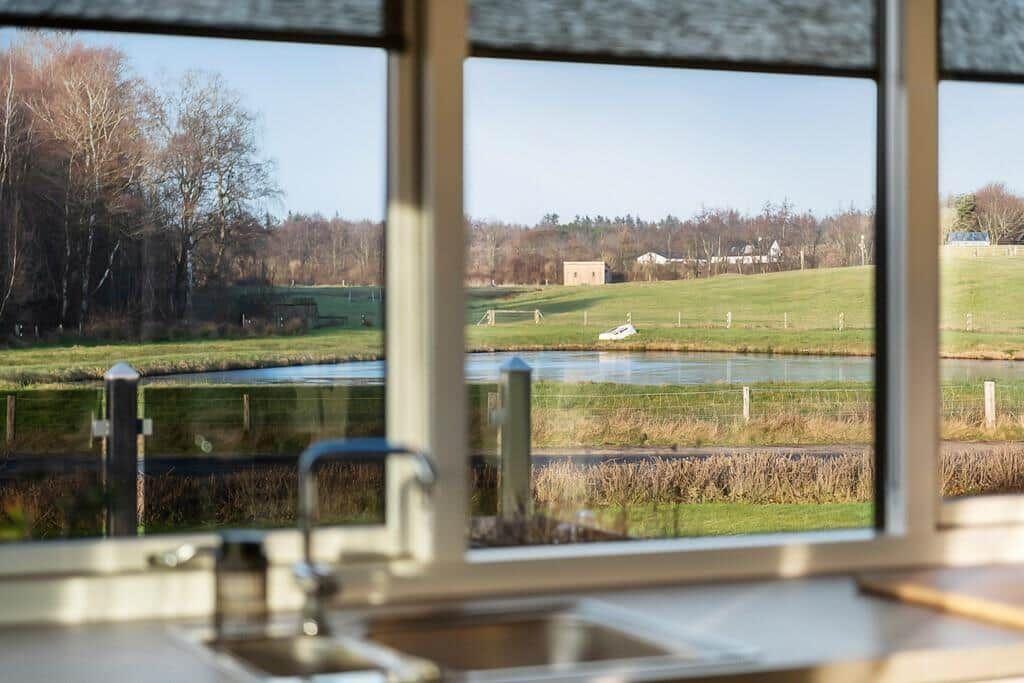 Küchenfenster mit Blick auf Fluss und Wiesen