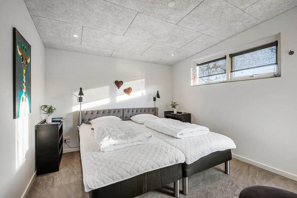 Schlafzimmer mit Doppelbett, zwei Nachttischen und Fenstern mit Blick.