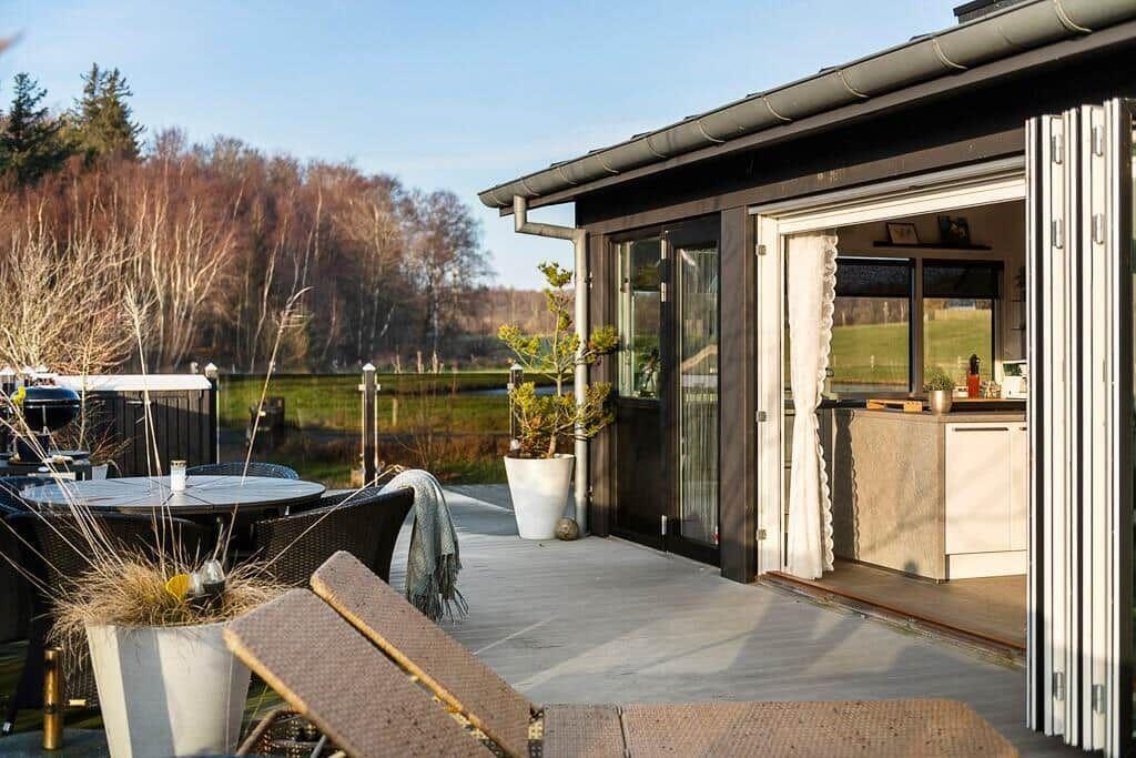 Terrasse mit Sitzgelegenheiten und Blick auf einen See.