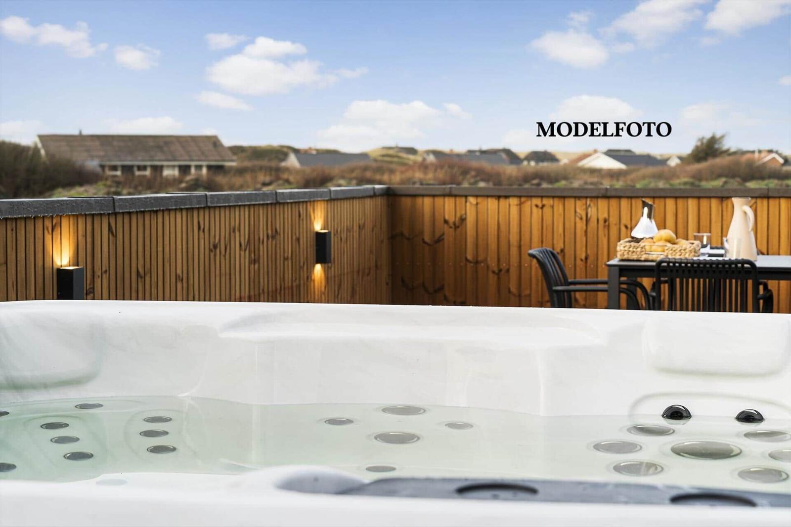 Eine Whirlpool-Terrasse mit Holzgeländer und Sitzgelegenheit im Hintergrund.