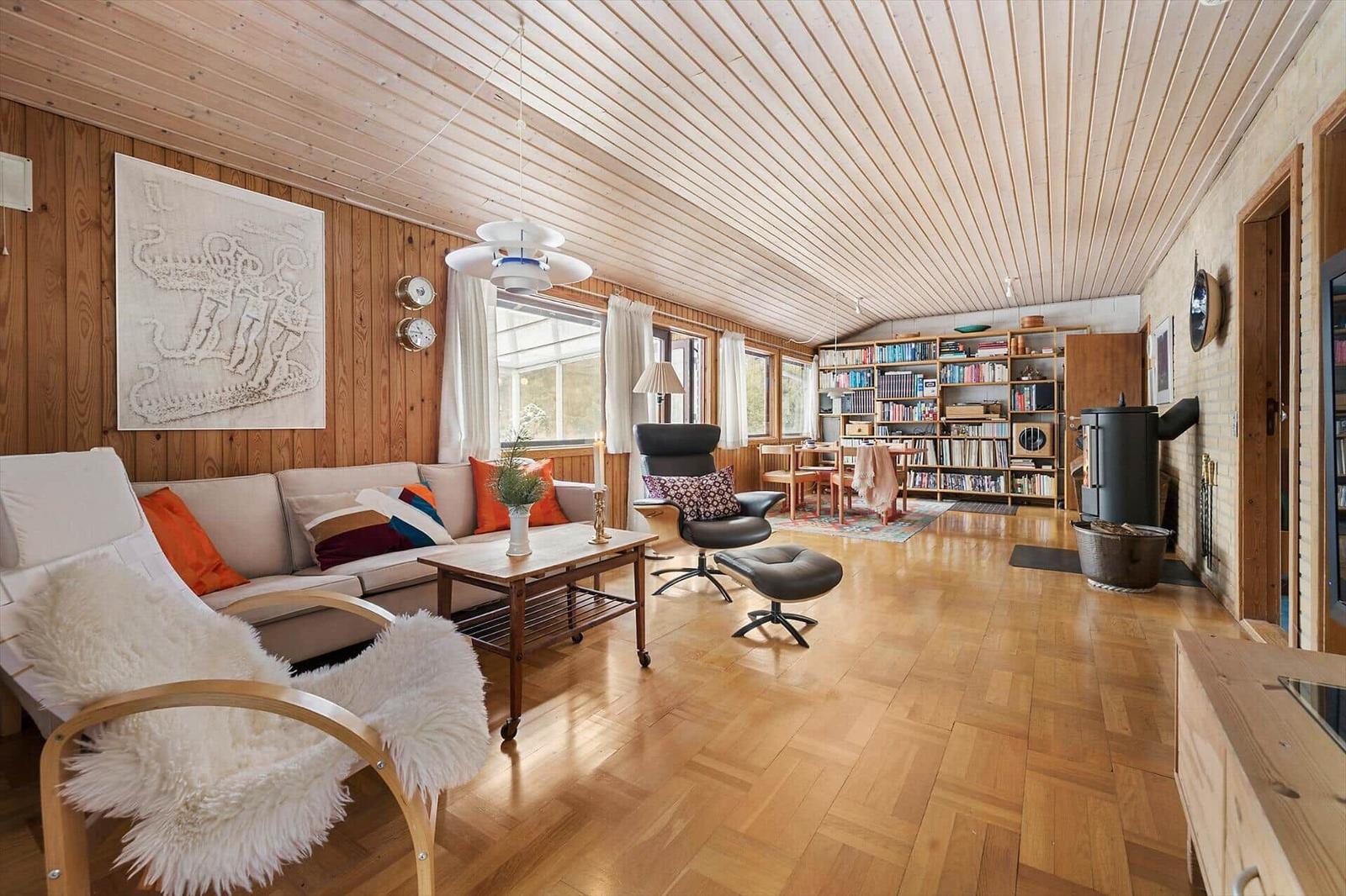 Living room with sofa, chair, bookshelf, and wooden floor.