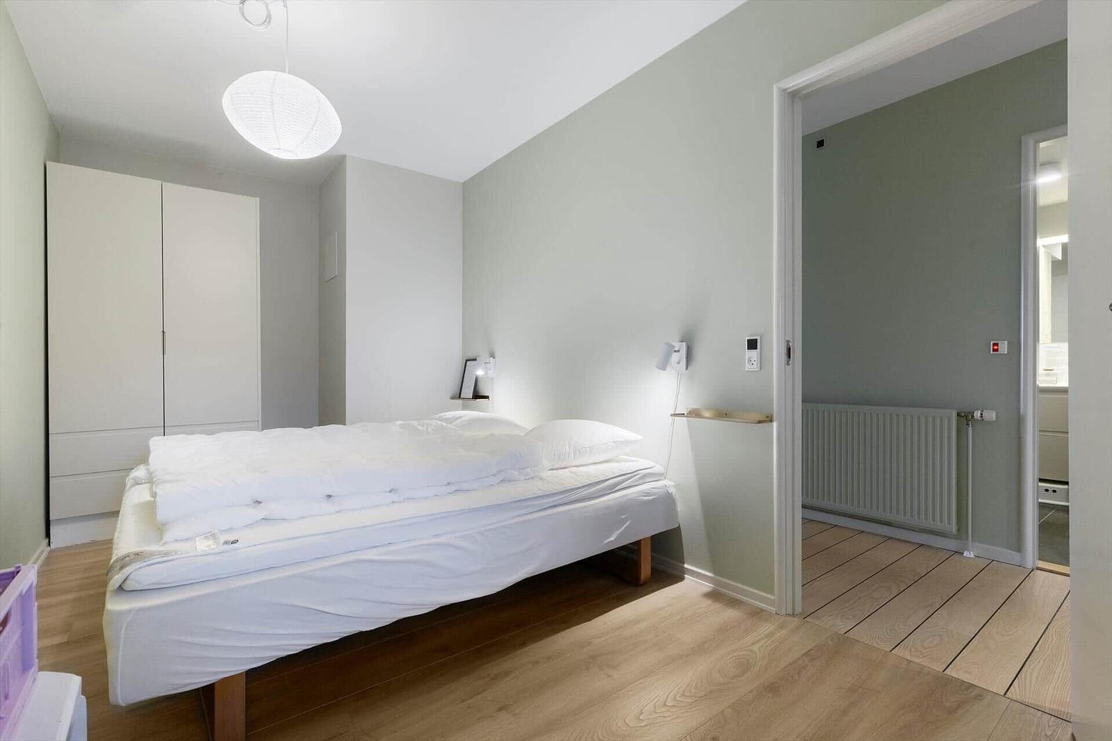 Bedroom with bed, wardrobe, and adjacent bathroom.