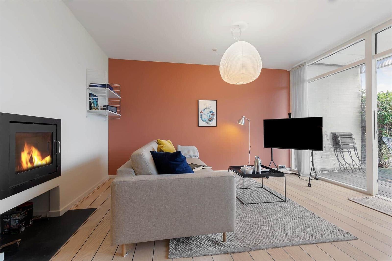 Living room with sofa, fireplace, and TV. Access to terrace.
