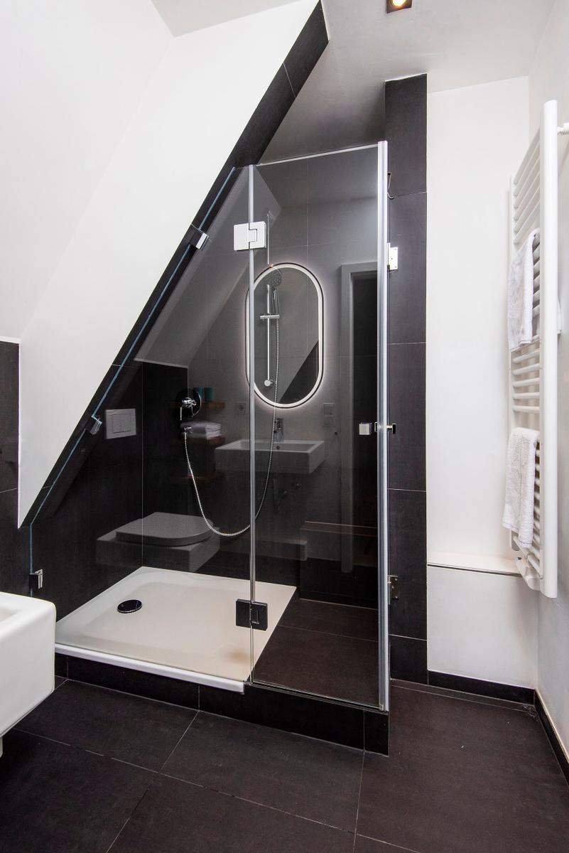 Badezimmer mit Dusche, Waschbecken und Heizkörper