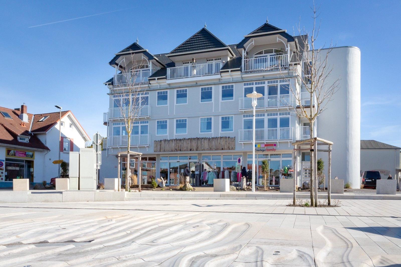 Modernes Gebäude mit Balkonen und Glasfassade an Straße