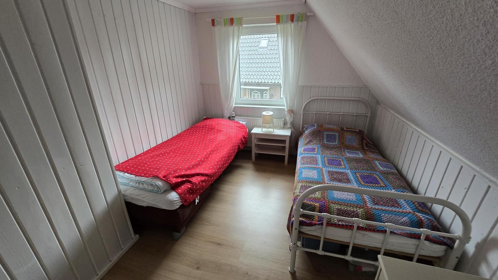 Zimmer mit zwei Betten, Fenster und Nachttisch