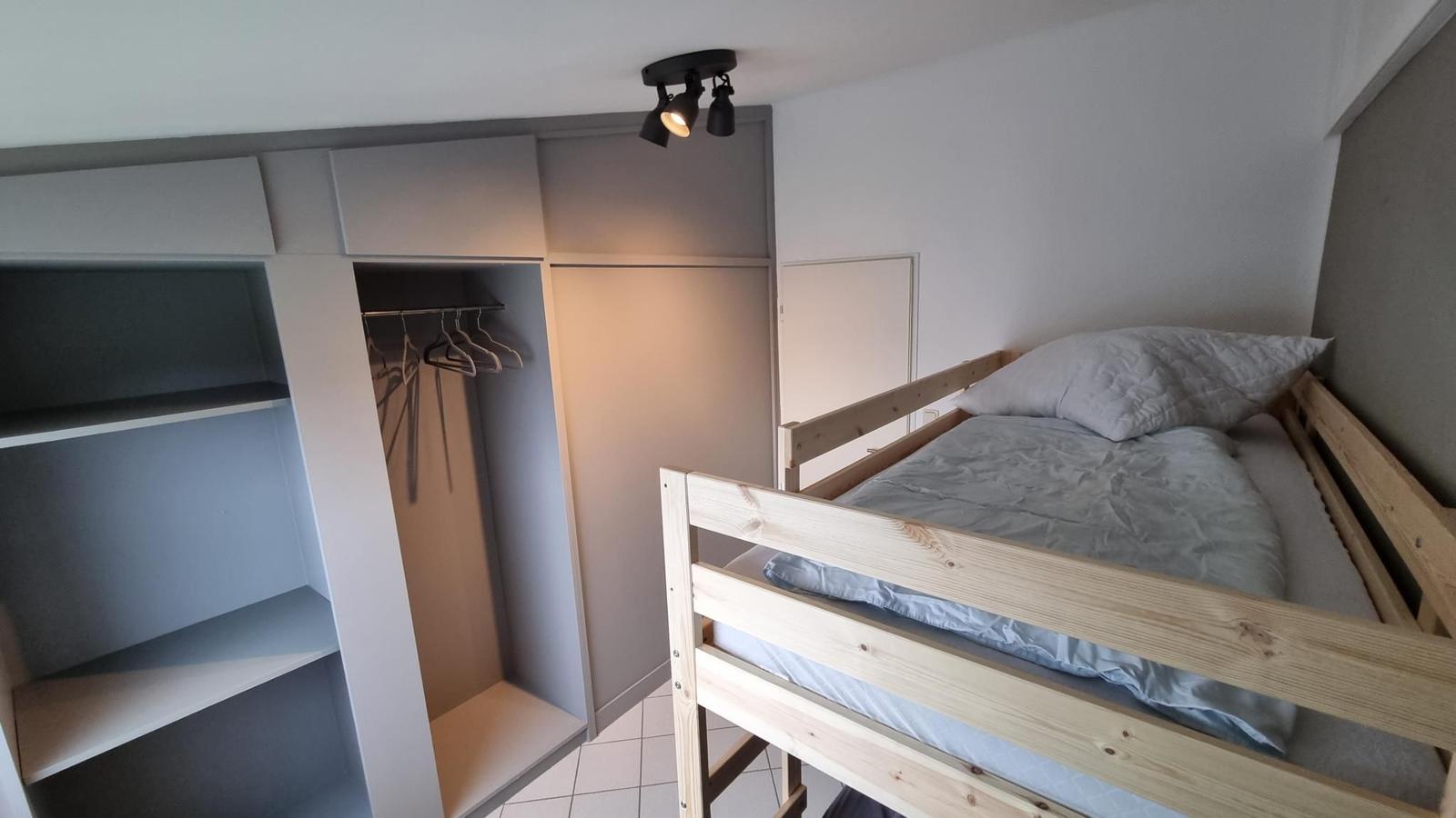 Ein Schlafzimmer mit einem Doppelstockbett und einem Kleiderschrank.
