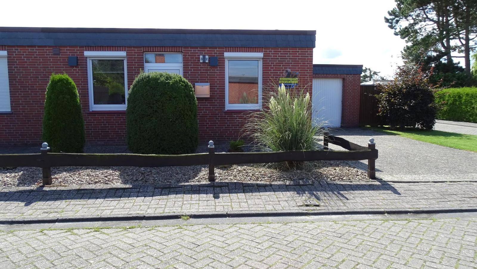 Rotes Backsteingebäude mit Fenstern und Garagen门前有修剪整齐的灌木和铺砌路面