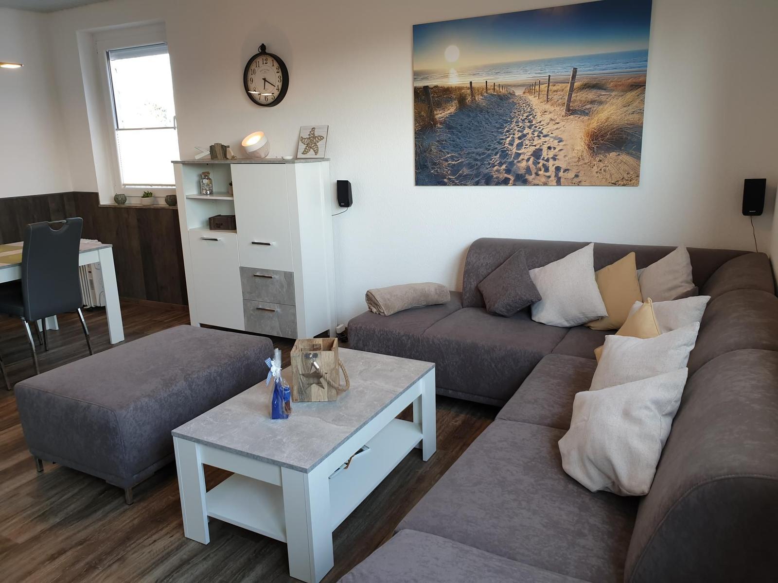 Living room with gray sofa, coffee table, and beach artwork on the wall.