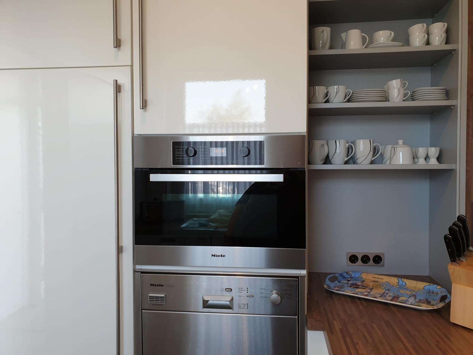 Kitchen with built-in oven, dishwasher, and dish cabinet.