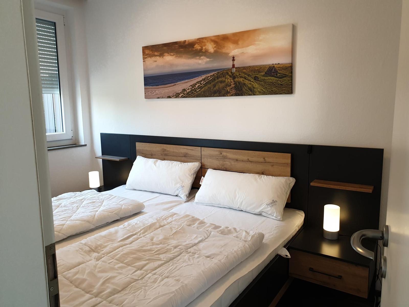 Bedroom with double bed, nightstand, and wall art