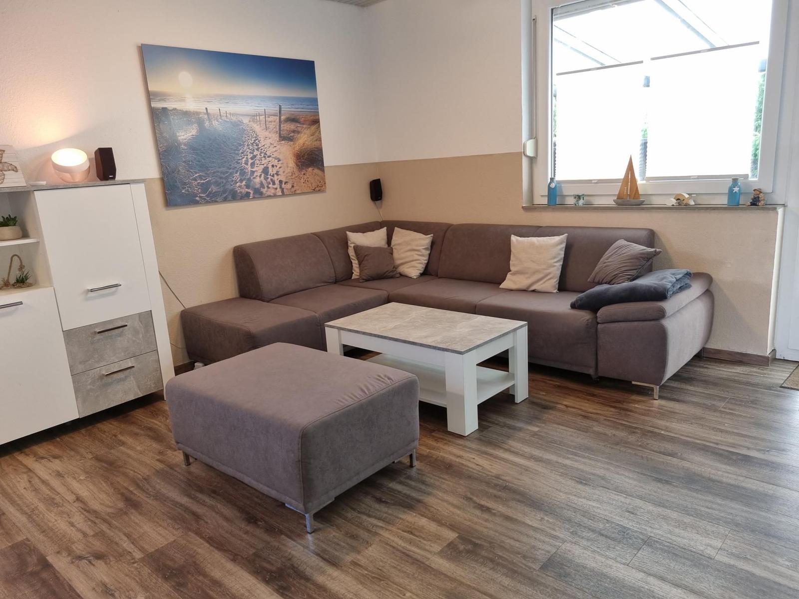 Living room with corner sofa, coffee table, and wooden floor.