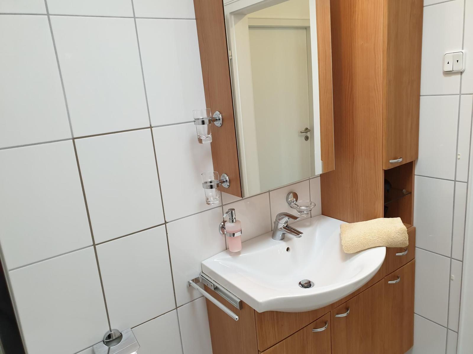 Bathroom with sink, mirror, and wooden cabinet.