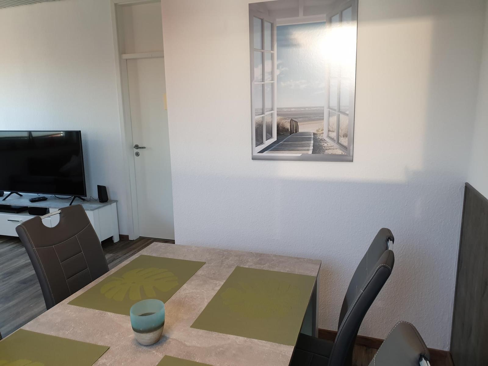 Dining table with chairs and wall picture of a beach.