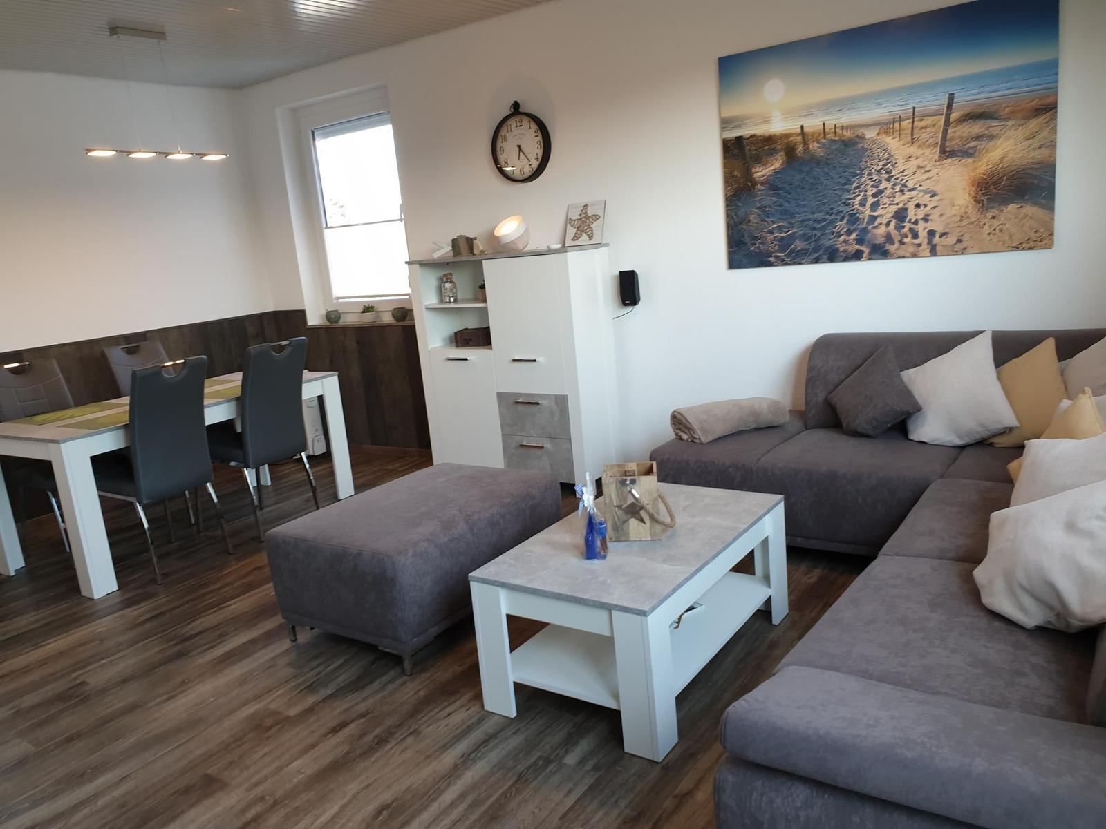 Living and dining area with sofa, table, and wall art