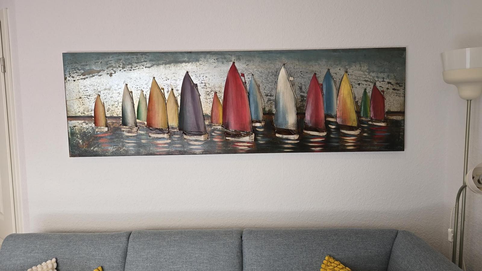Wandbild mit bunten Segelbooten über grauem Sofa