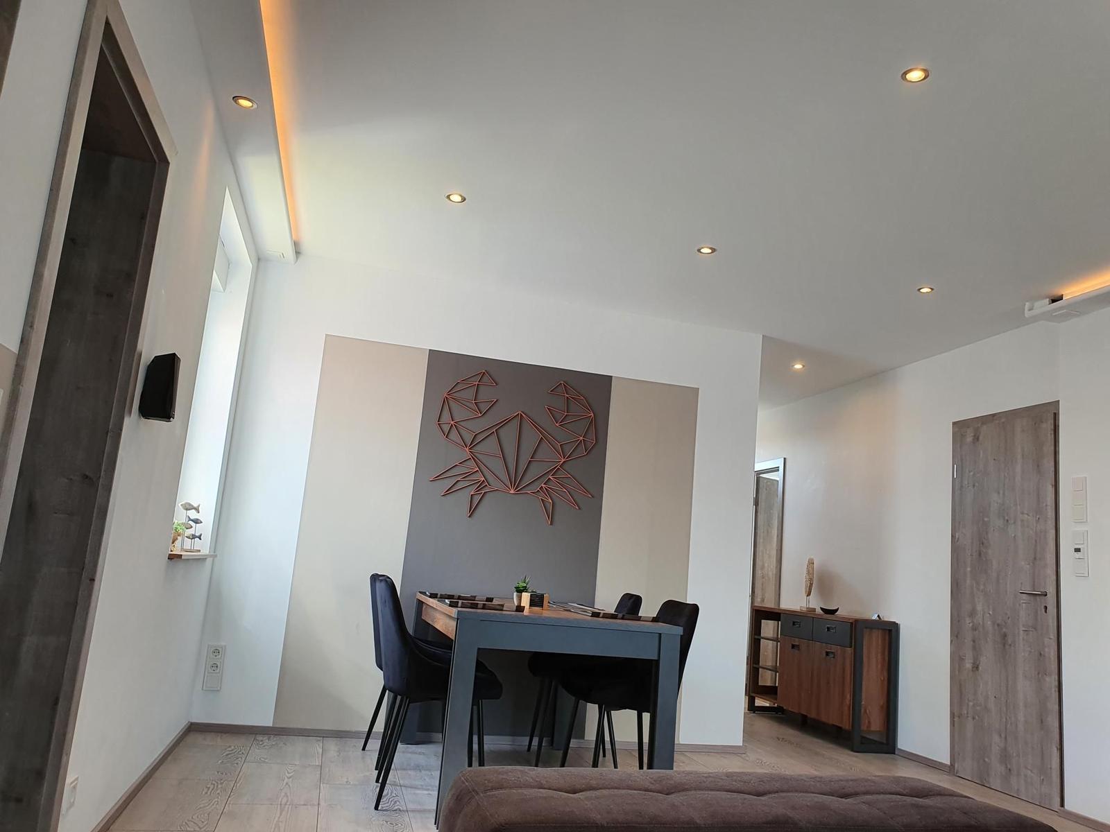 Essbereich mit Tisch, Stühlen und Wanddekoration