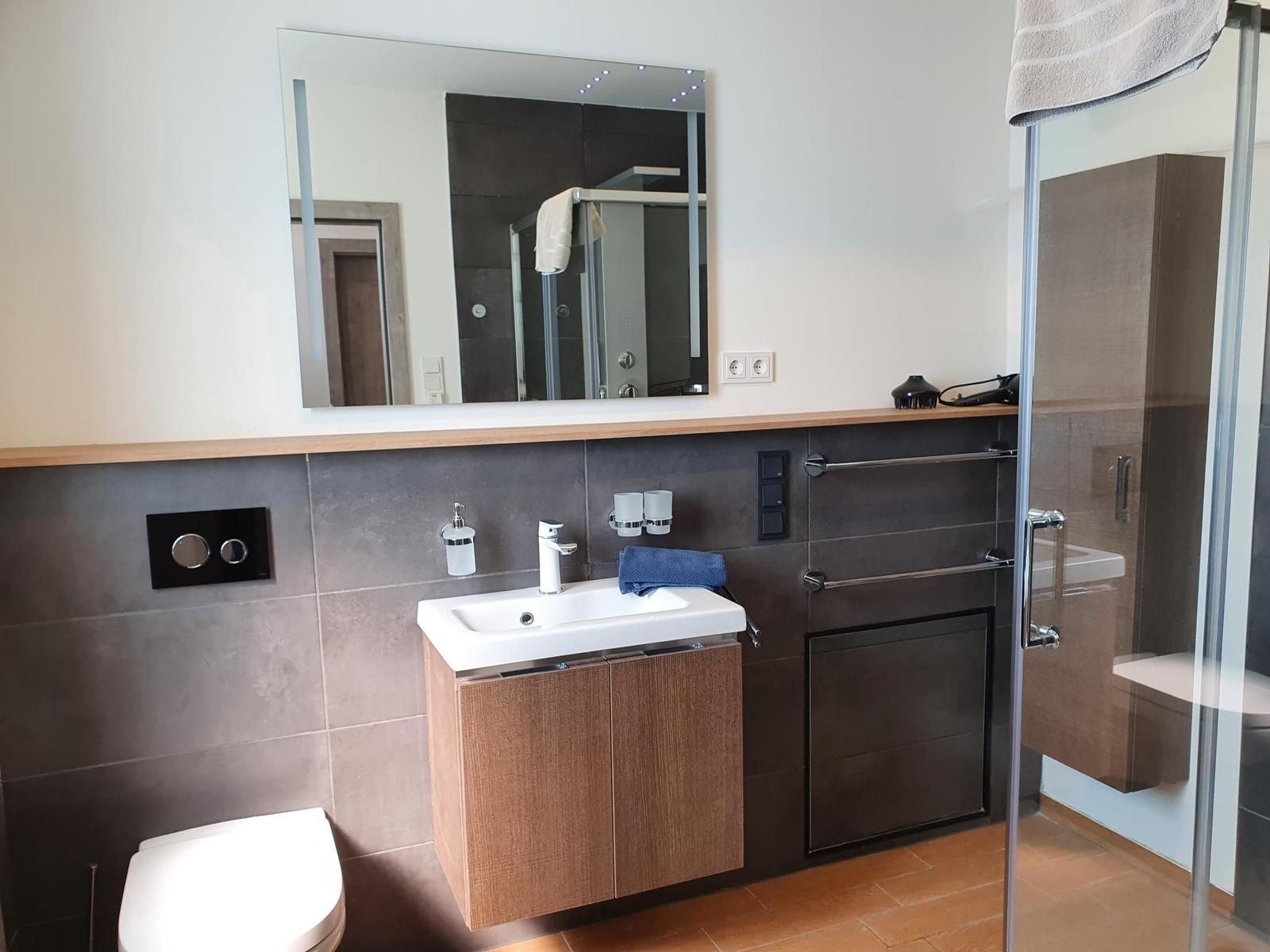 Badezimmer mit Dusche, Waschbecken und Toilette