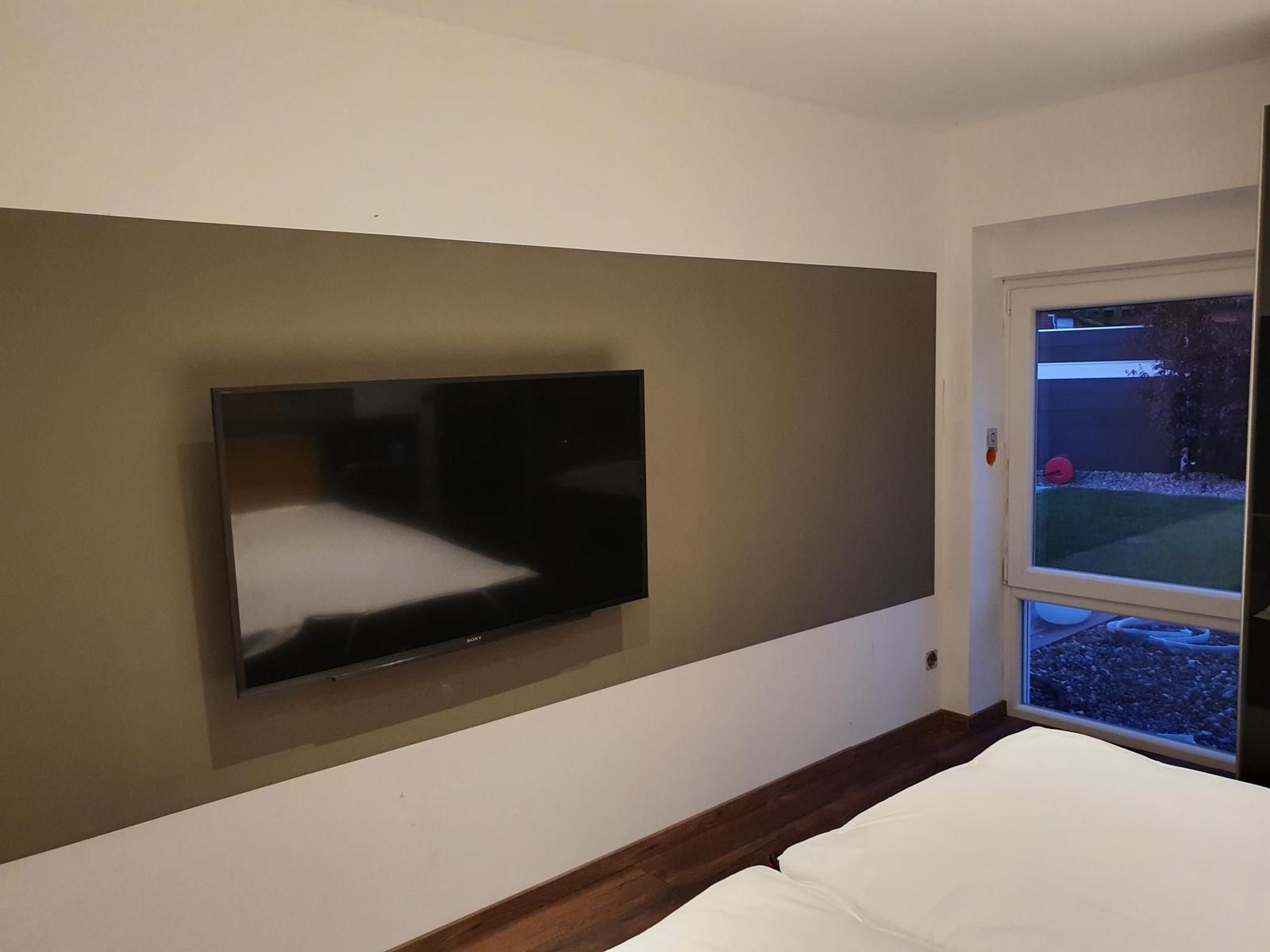 Schlafzimmer mit Fernseher und Blick auf Garten