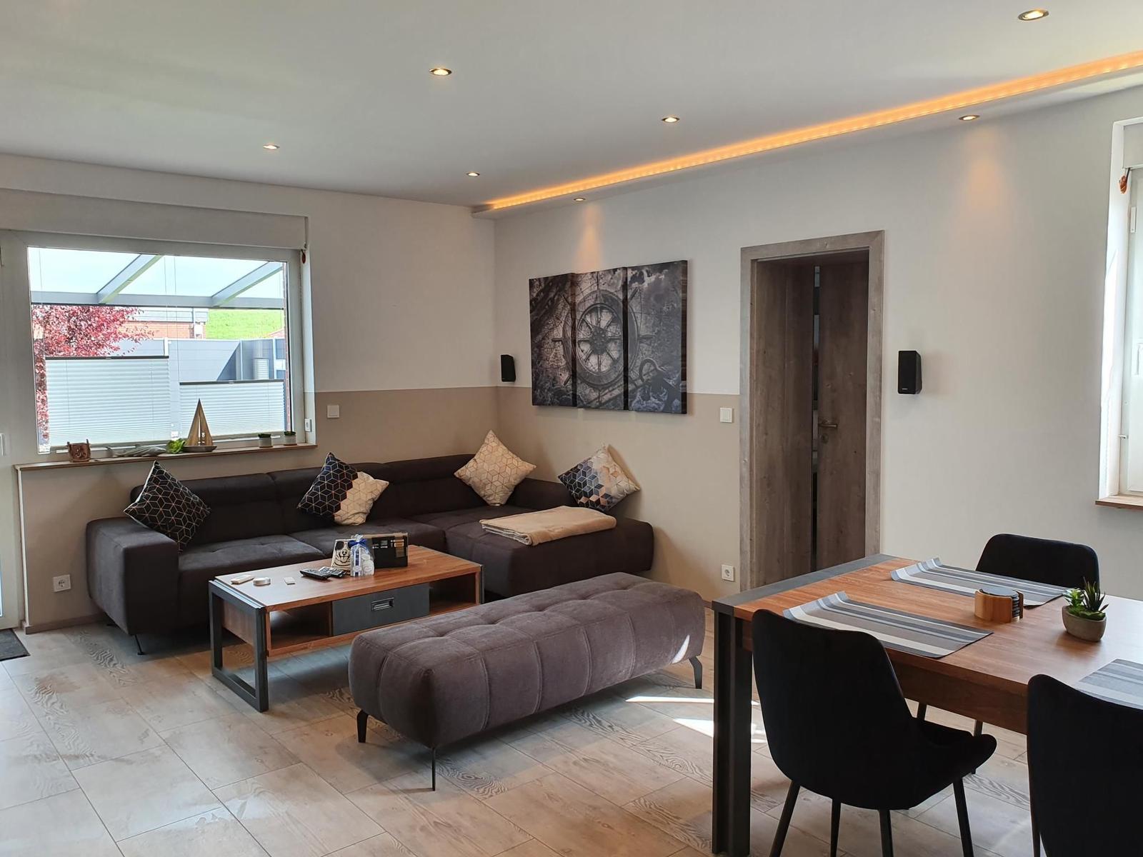 Wohn- und Essbereich mit Sofa, Tisch und Stühlen.