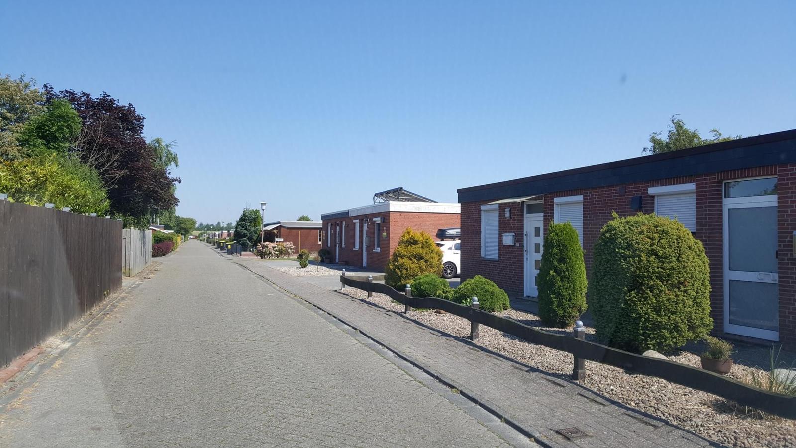 Reihen von modernen Häusern mit gepflastertem Weg und grüner Umgebung.