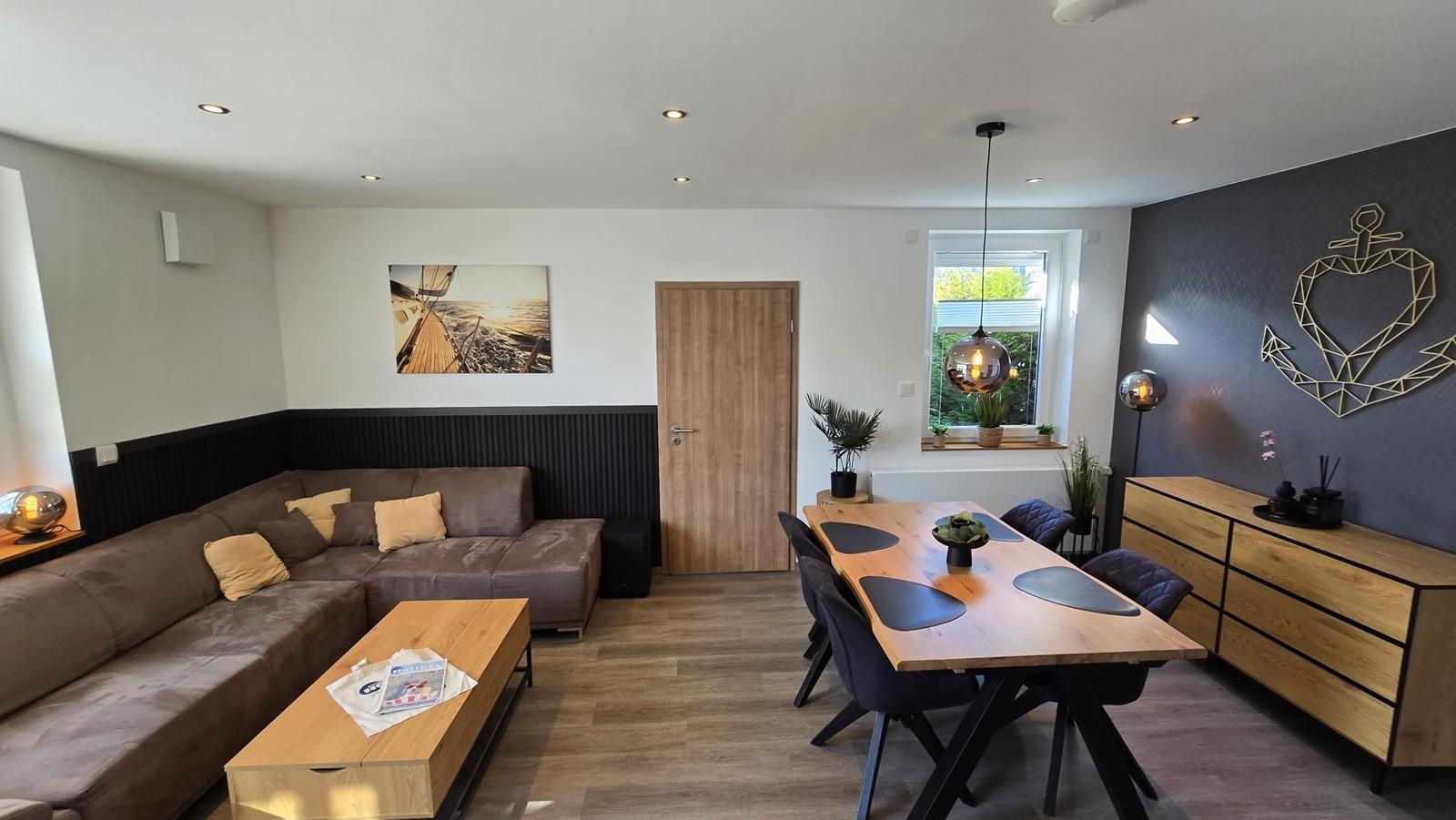 Wohn- und Essbereich mit Sofa, Tisch und Wanddekoration.