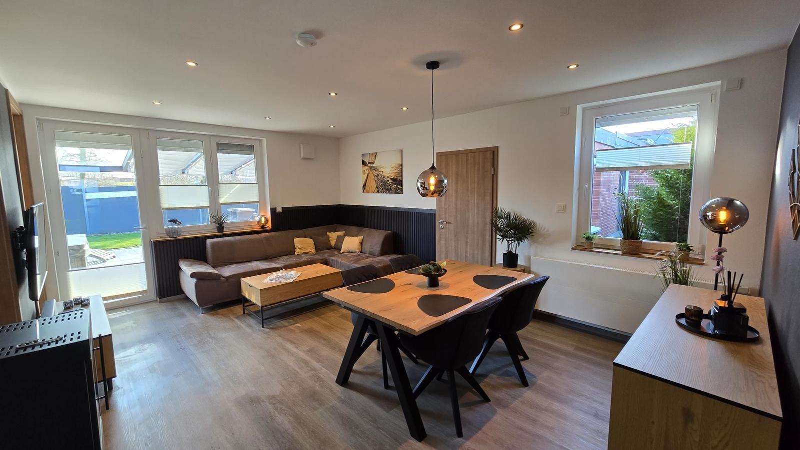 Wohn- und Essbereich mit Sofa, Esstisch und Blick auf Garten