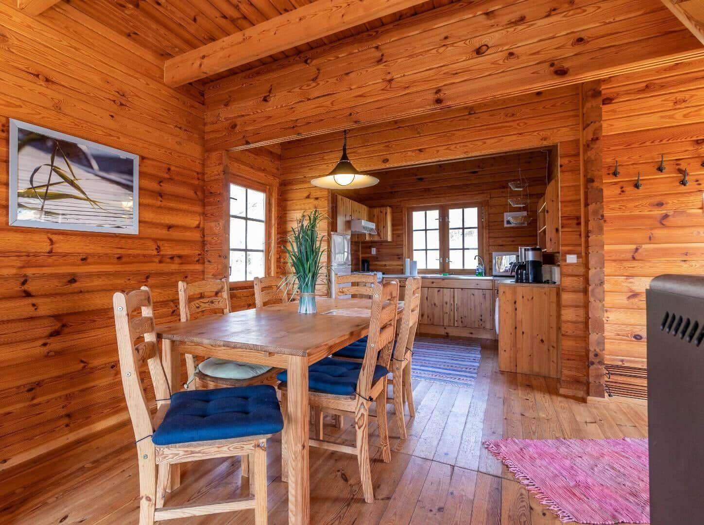 Esszimmer mit Holztisch, Stühlen und Blick in die Küche