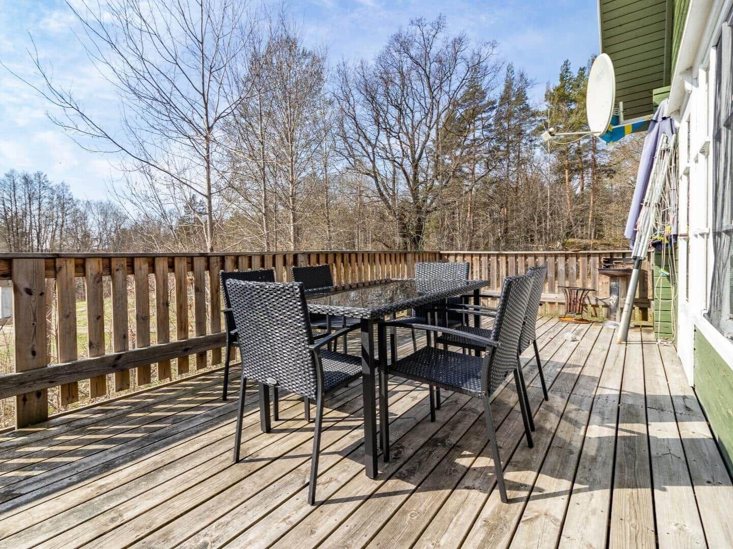 Holzterrasse mit Sitzgruppe und Blick in den Wald.