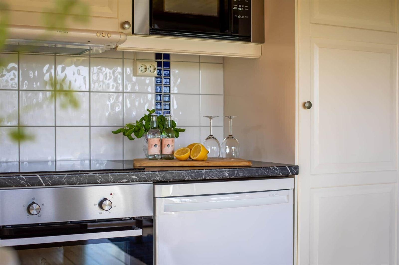 Küche mit Dunstabzug, Mikrowelle, Herd und Spülmaschine.