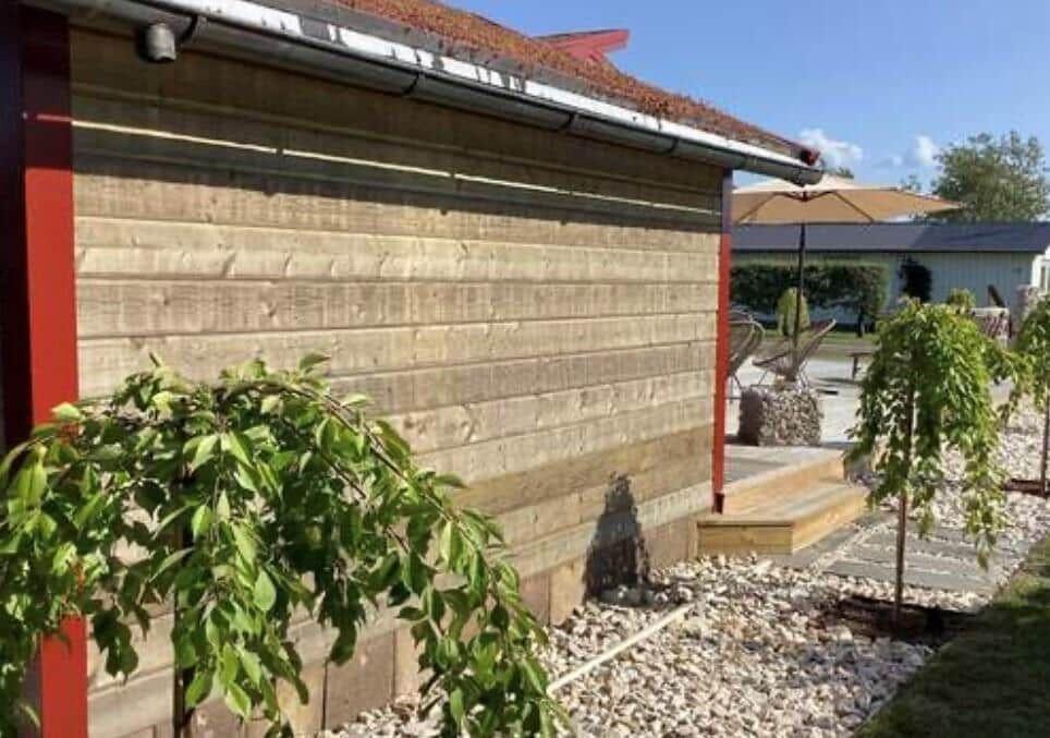 Holzwand, Terrasse mit Sonnenschirm und Gartenbereich