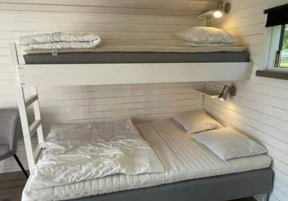 Obere und untere Schlafstelle mit Matratzen und Kissen.