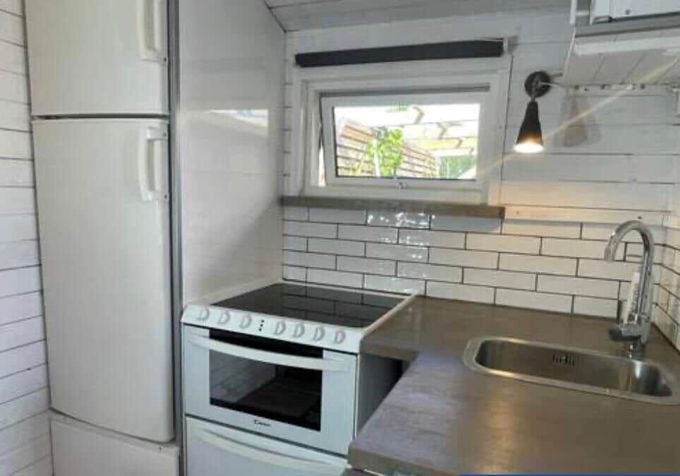 Küche mit Kühlschrank, Herd und Fenster