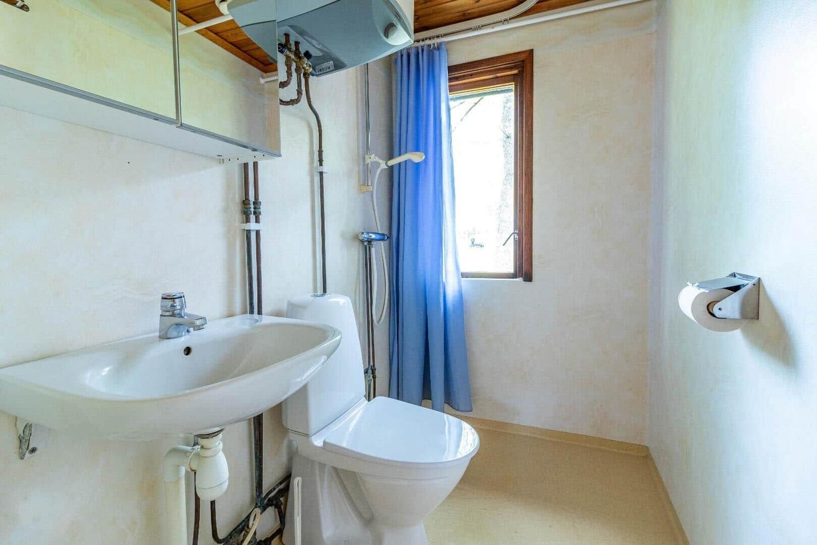 Badezimmer mit Waschbecken, Toilette und Duschvorhang.