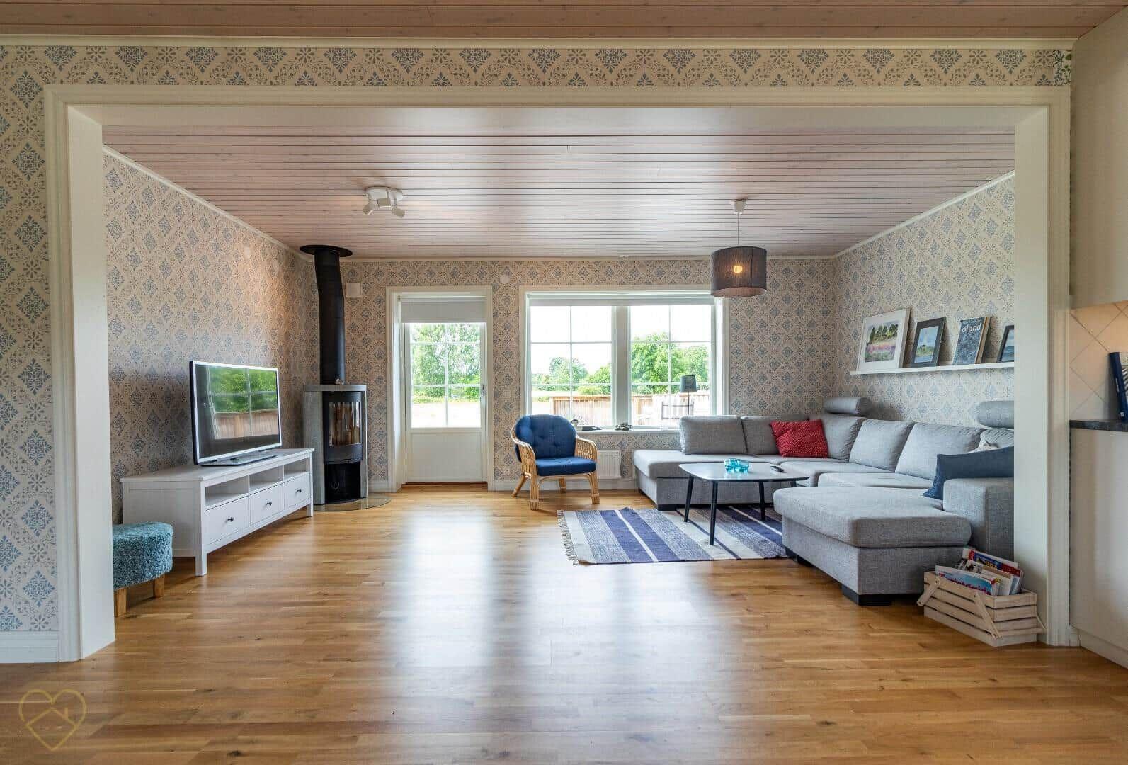 Wohnzimmer mit Sofa, Kamin und Holzboden.