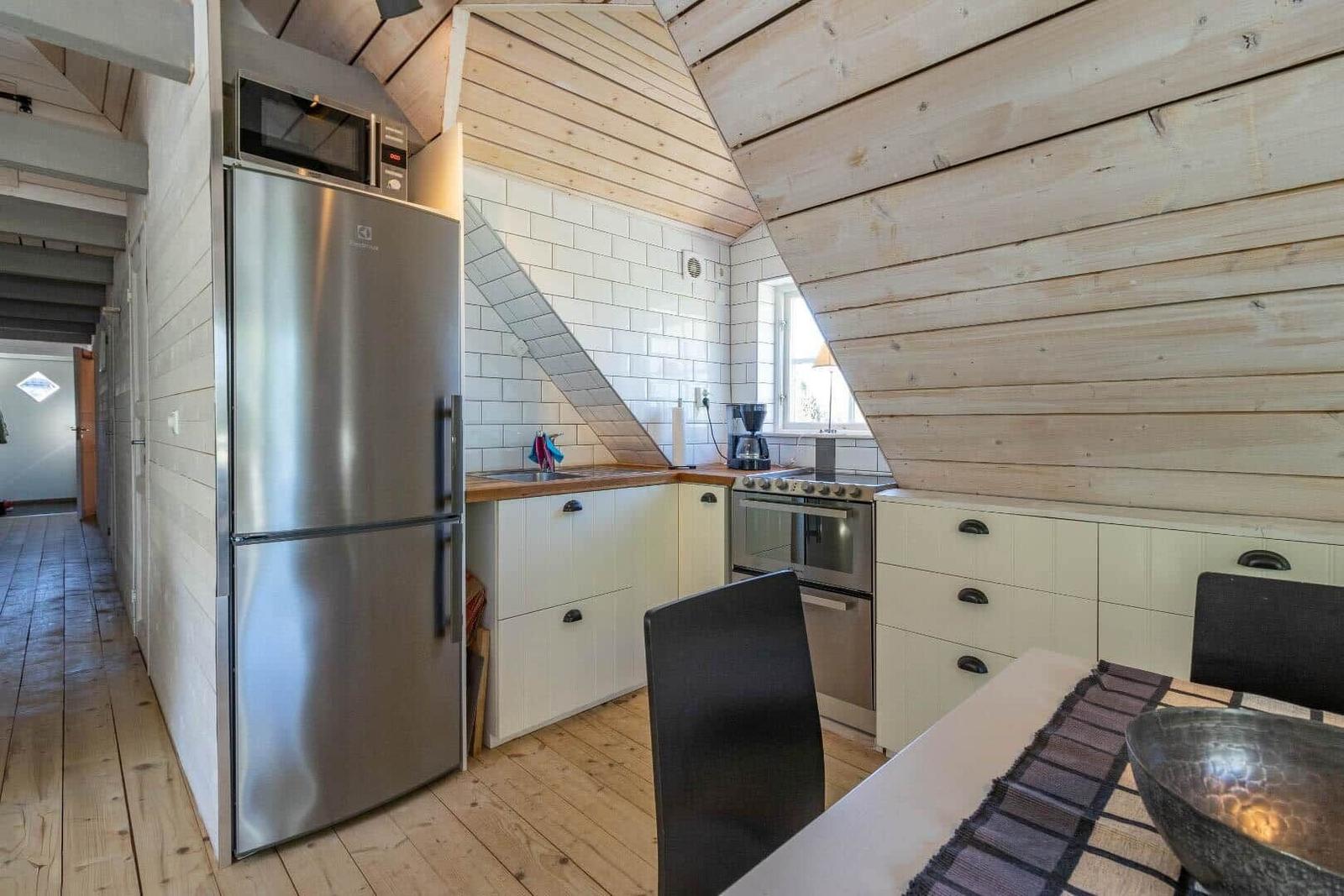 Küche mit Kühlschrank, Herd und Essbereich unter Holzdach
