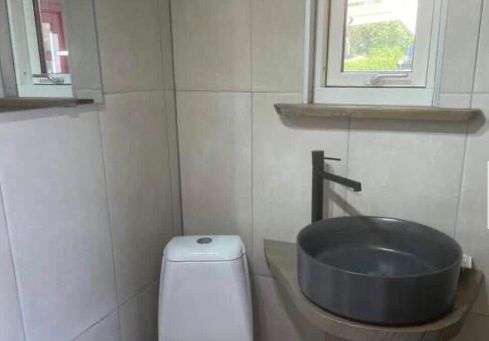Badezimmer mit Waschbecken, Toilette und Fenster