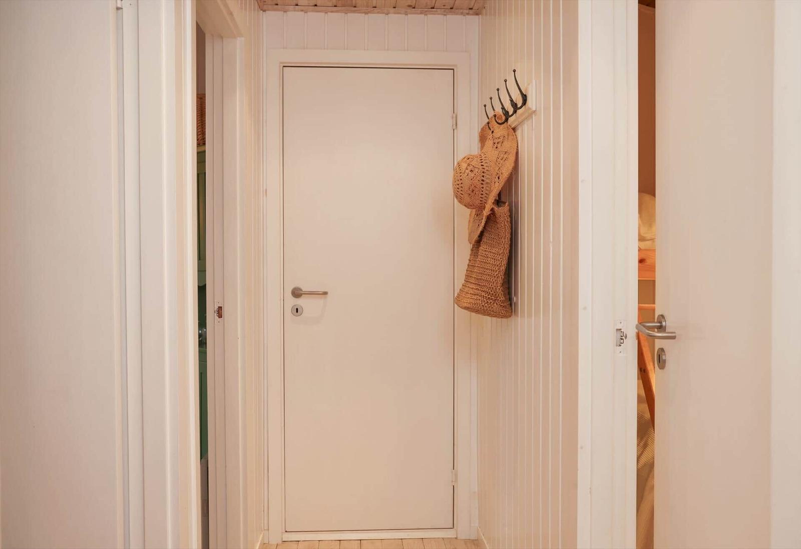 Flur mit weiße Tür und Strohhut an Wandhaken
