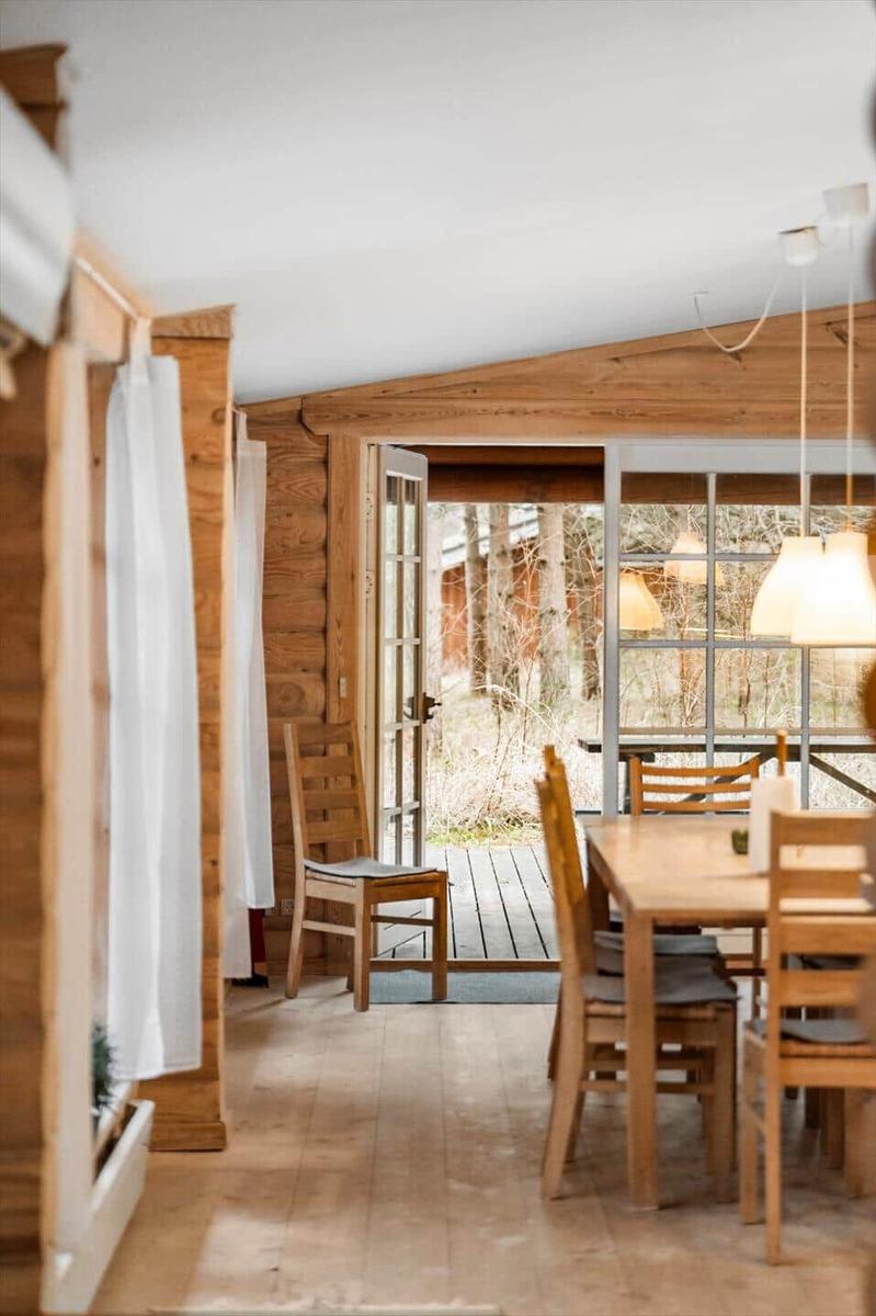Esszimmer mit Holztisch, Stühlen und Blick auf Terrasse.