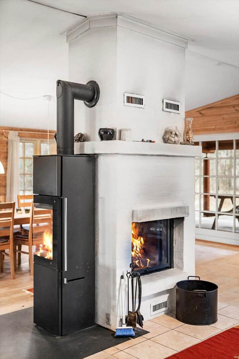 Wohnzimmer mit Kamin und Holzofen. Flammen brennen in beiden Brennern.
