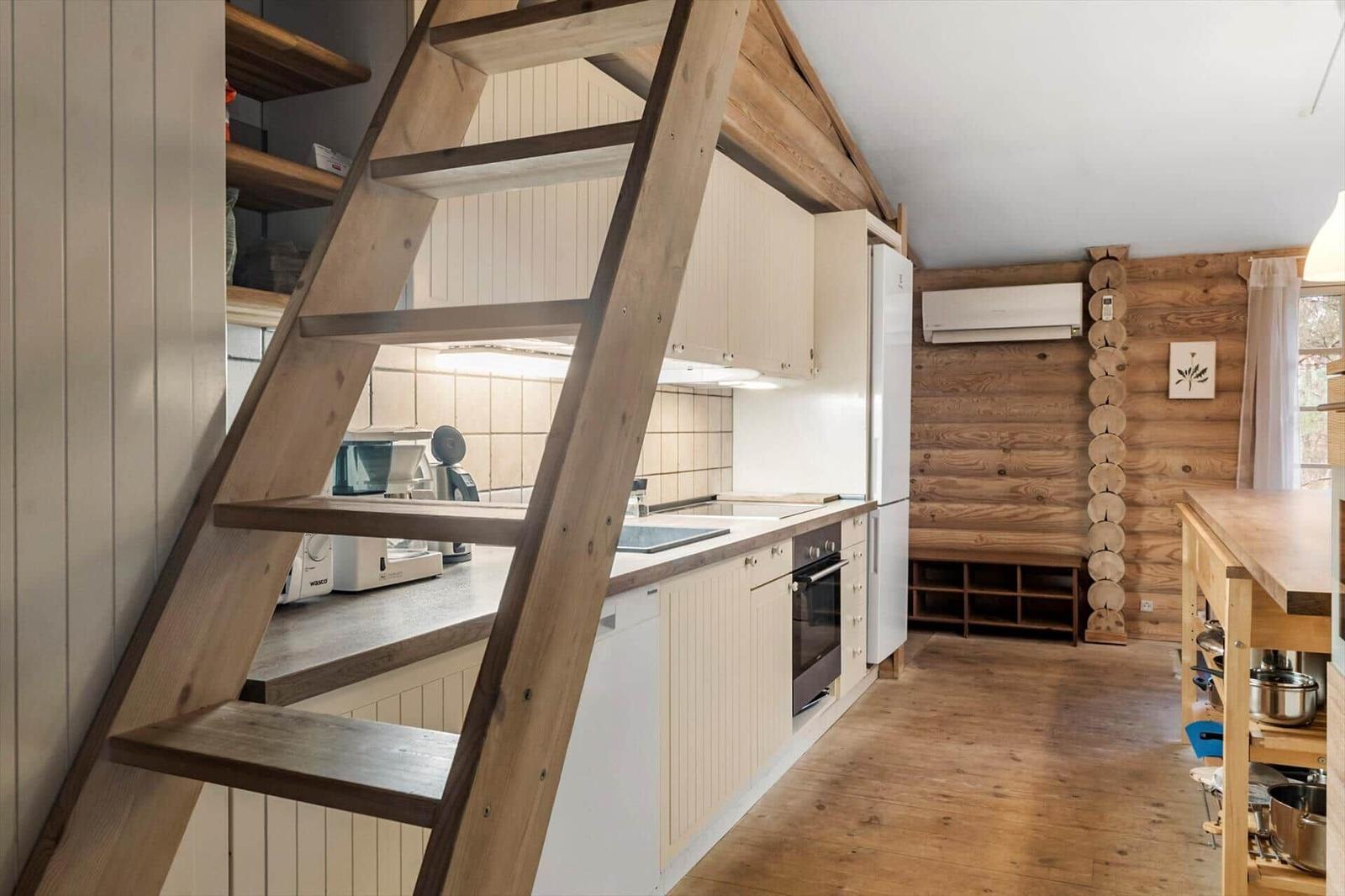Küche mit Holztreppenstufe und Küchenzeile.