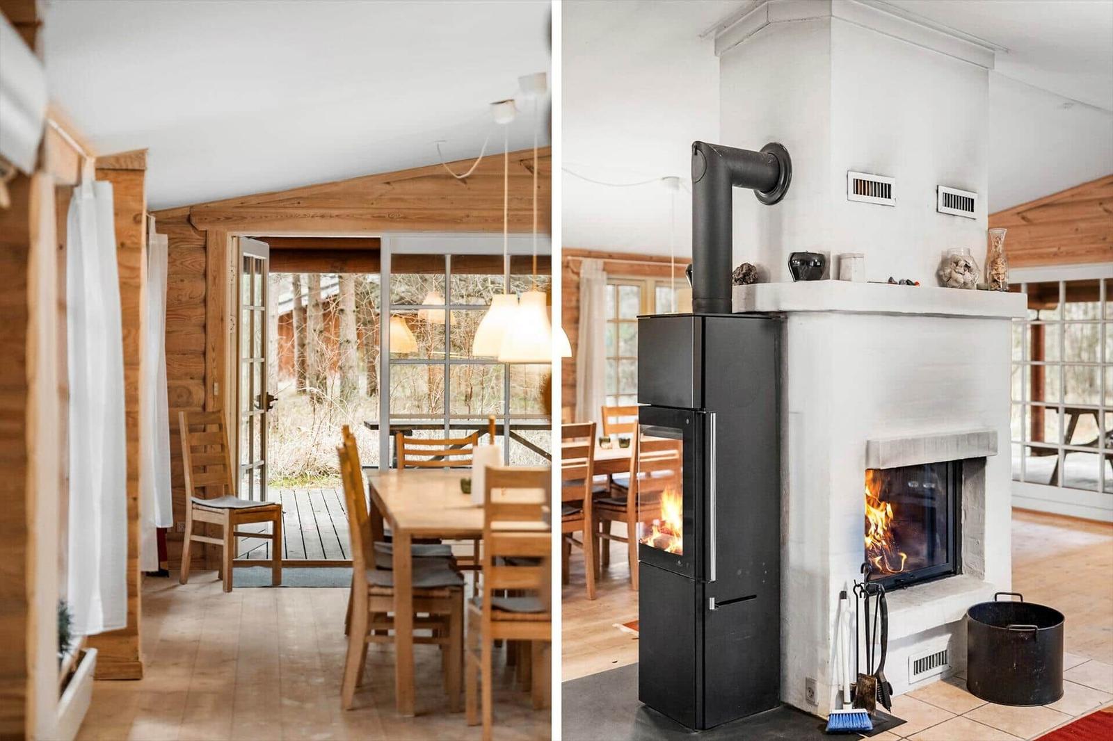 Essbereich mit Holztisch und Stühlen. Kamin mit brennendem Holzofen.