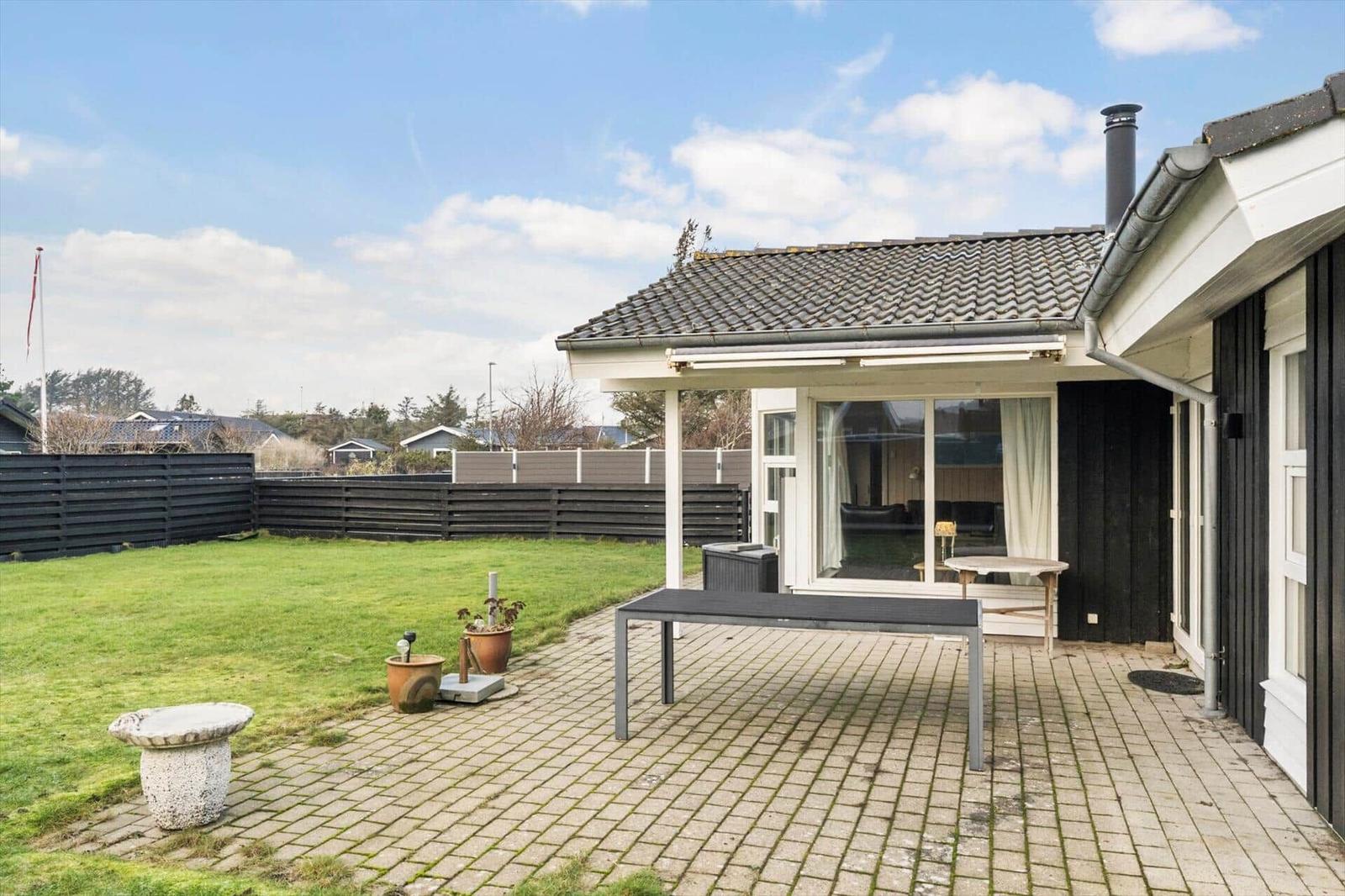 Backyard with terrace, grill area, and garden. Large glass window to interior.