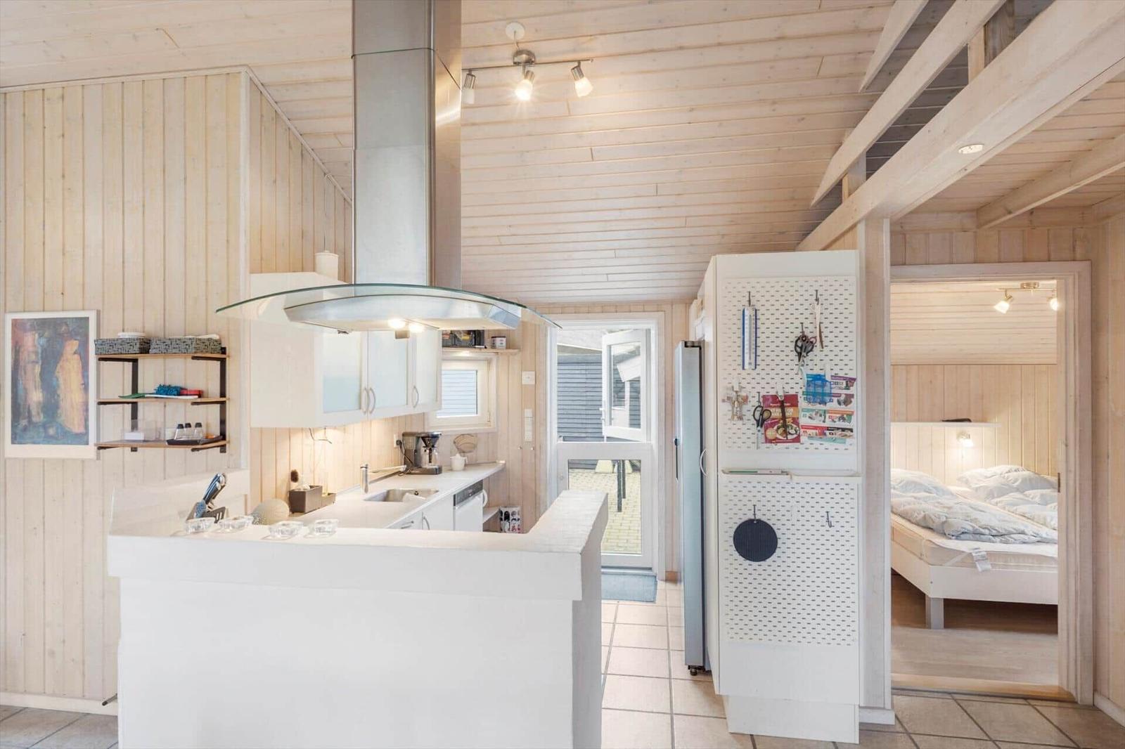 Kitchen with dining area and bedroom in the background.