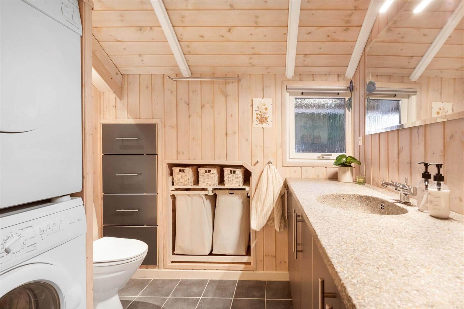 Bathroom with washing machine, toilet, and sink