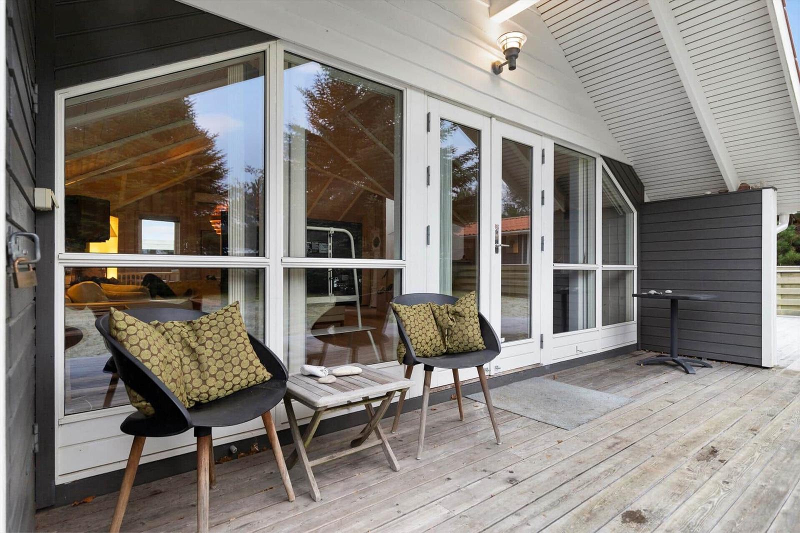 Deck with two chairs, table, and glass doors to the unit.