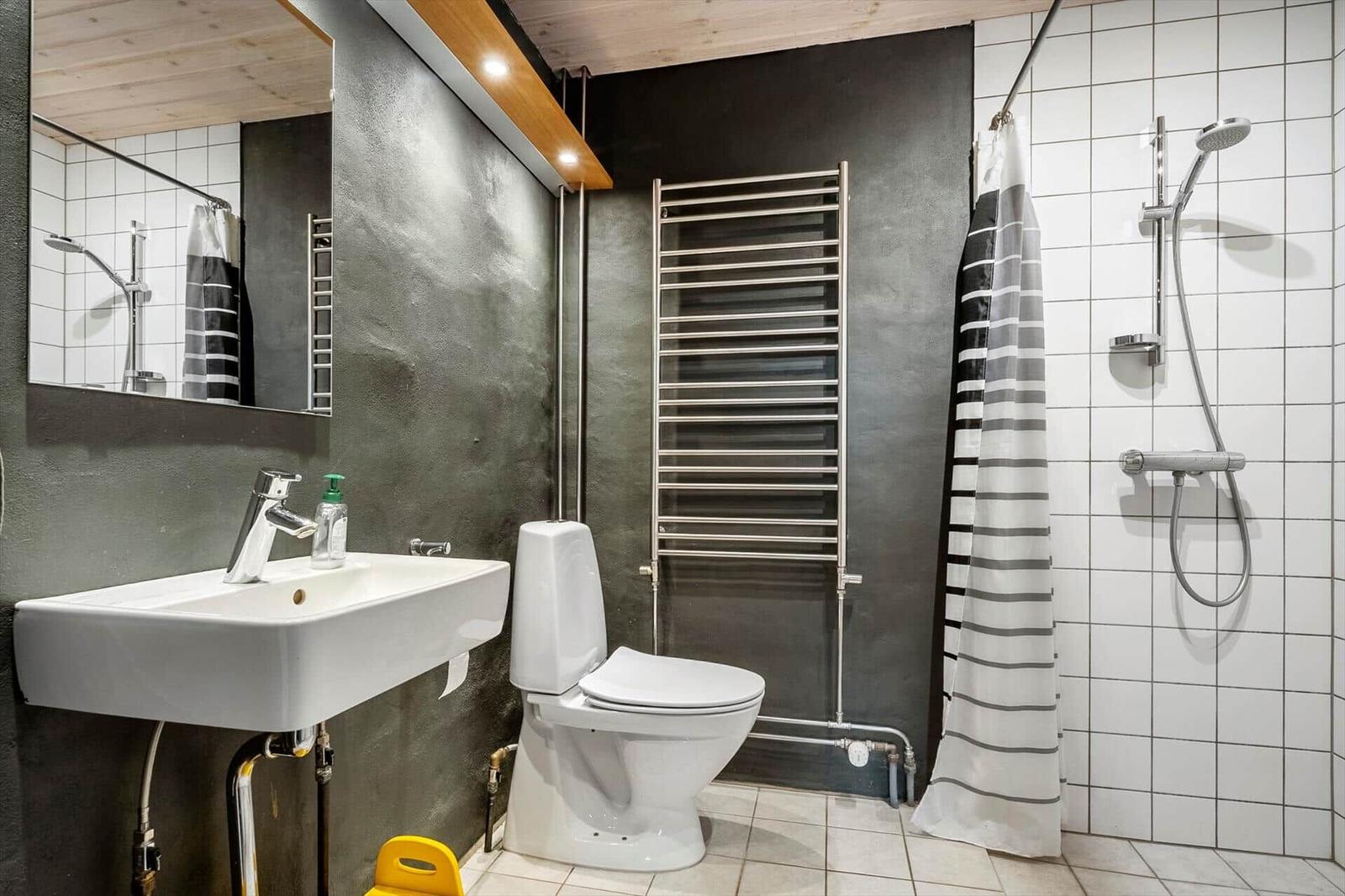 Badezimmer mit Toilette, Waschbecken und Dusche mit Duschvorhang.