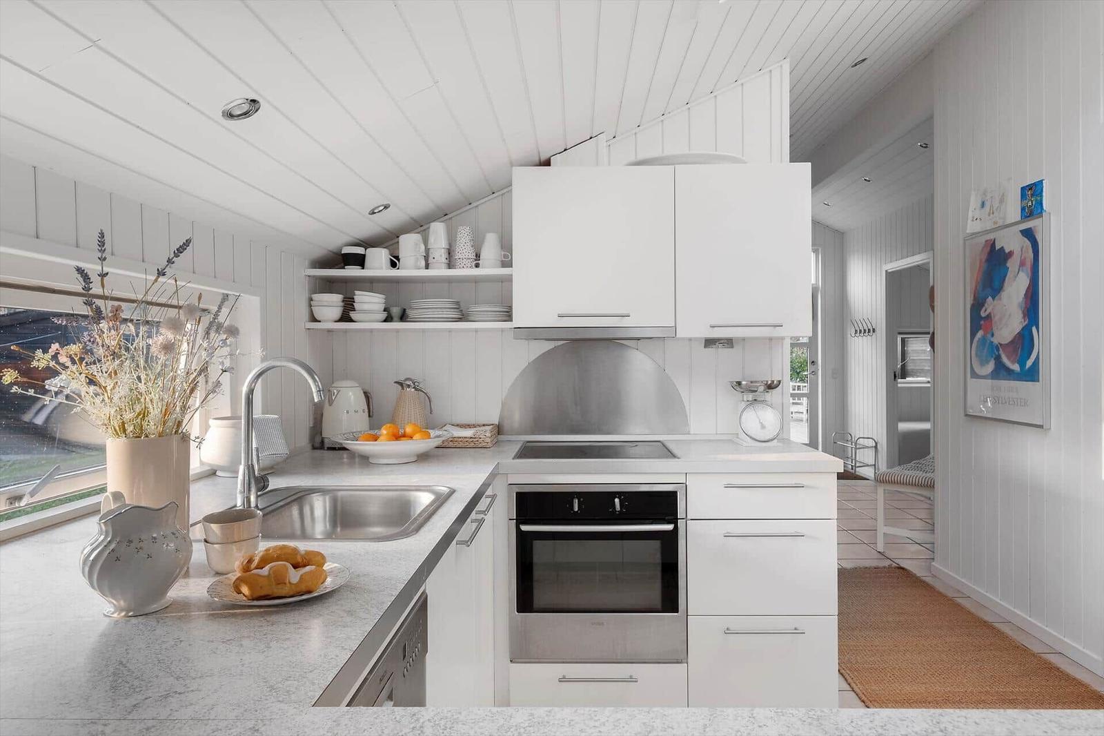 Kitchen with white cabinets, stainless steel sink, and built-in oven.