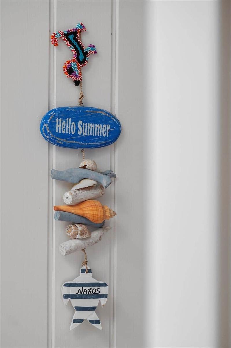 A summer decoration with seashells and a fish from Naxos hangs on the wall.